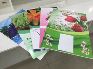 Gia công: cán màng bóng/màng mờ; bồi format làm tấm nền, đóng khoen 2 lỗ trên đầu để xỏ dây treo lịch