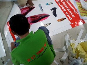 Tấm poster PP giới thiệu những mẫu giày cao gót, giày nữ công sở mới thu hút được sự chú ý của bạn gái hơn. Nhân viên của In Kỹ Thuật Số đang thực hiện gia công cán màng cho tấm PP chống nhăn, chống bụi, chống gảy gập.