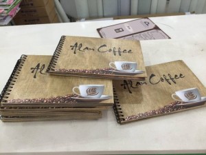 In menu quán cafe dạng cuốn cho Alan Coffe, họa tiết bao bố đựng cafe, hạt cafe đen rang xay nguyên chất được giữ nguyên cho cuốn menu thêm thu hút và đậm chất