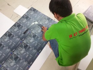 Nhân viên gia công thực hiện cắt rời menu PP cán format trước khi ghép cuốn menu, thực đơn tại In Thực Đơn