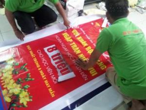 Nhân viên gia công In Kỹ Thuật Số thực hiện cuốn biên, đóng khoen poster in từ chất liệu hiflex