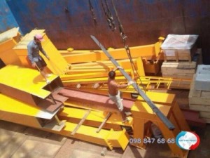 Đội nhân công bốc xếp thực hiện công việc của mình - sắp xếp khung nhà thép tiền chế vào khoang sà lan