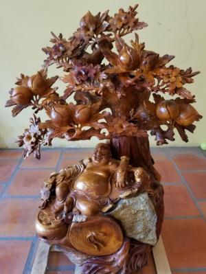 Di lặc ngồi gốc đào tươi như hoa