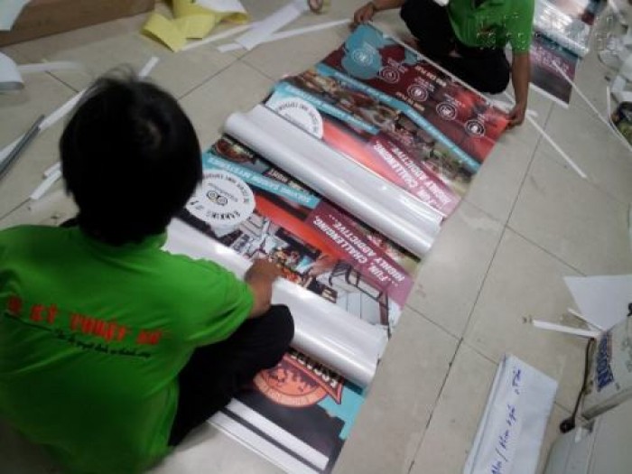 Cố định nẹp hai đầu khi lắp poster vào banner cuốn